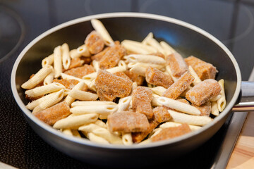 penne pasta with bolognese sauce in a pan