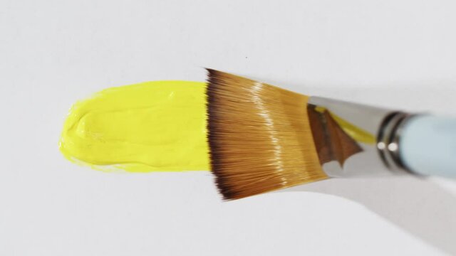 Brush painting with yellow color close-up, art concept. acrylic paint or fluid liquid ink, drawing watercolor abstract background.