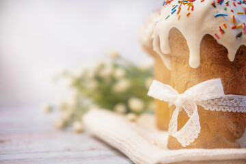 Easter cake, with a porcelain rabbit in the background, on a white table. Selective focus. Copy the place for the text.
