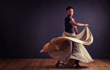 Feel the motion. Female contemporary dancer in a dramatic pose against dark background. - obrazy, fototapety, plakaty