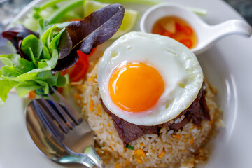 Fried egg, beef fried rice with fried egg on glass table, fast food concept.
