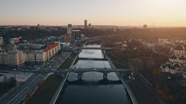 Sunset city downtown river bridge, establishing aerial shot during amazing sunset. European old city landscape. Downtown city life concept. Architecture, development, transportation and infrastructure