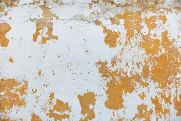 Texture of an old plastered wall with shabby whitewash and cracks.