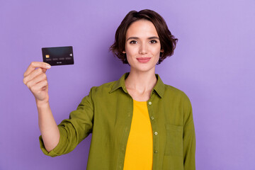 Photo of young lovely girl hold bank card finance credit earnings isolated over violet color...