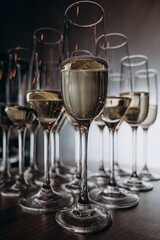 sparkling wine is poured into beautiful glasses standing on a wooden table