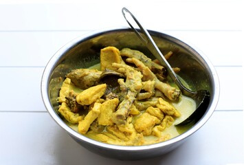 Opor Ayam Ceker, Indonesian Yellow Curry Traditional Food in a Bowl.