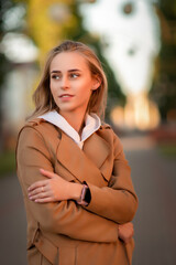 Young beautiful fair-haired girl in the park in early autumn.