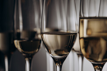 sparkling wine is poured into beautiful glasses standing on a wooden table