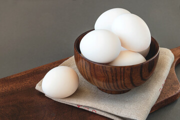 Fresh eggs in a wooden brown bowl, a symbol of the great Easter holiday. 