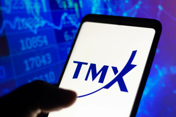 Fototapeta premium January 4, 2022, Brazil. In this photographic illustration, the logo of Toronto Stock Exchange (TMX), a stock exchange, is displayed on a smartphone with a stock market chart in the background.