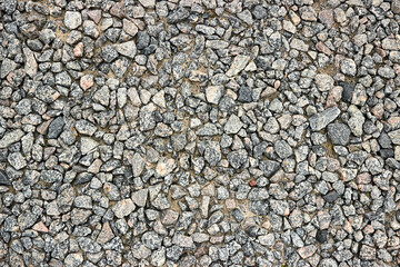 Small stone texture or gravel background. Dark grey closeup small rocks. Real grunge texture background and small stone. Pebbles stone texture seamless. Top view.