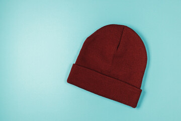 Wool knitted hat on blue background, mockup with Label
