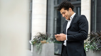 a work colleague is calling, A male manager in an official suit is holding a phone in his hands