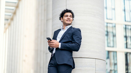 Uses the phone, Goes to the office confident satisfied portrait of an Italian male manager in an...