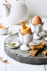 Perfect soft boiled egg in an egg cup with toast breakfast on the table. Traditional food for a...
