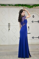 室内にて青いドレスを着た若く美しい女性のポートレート