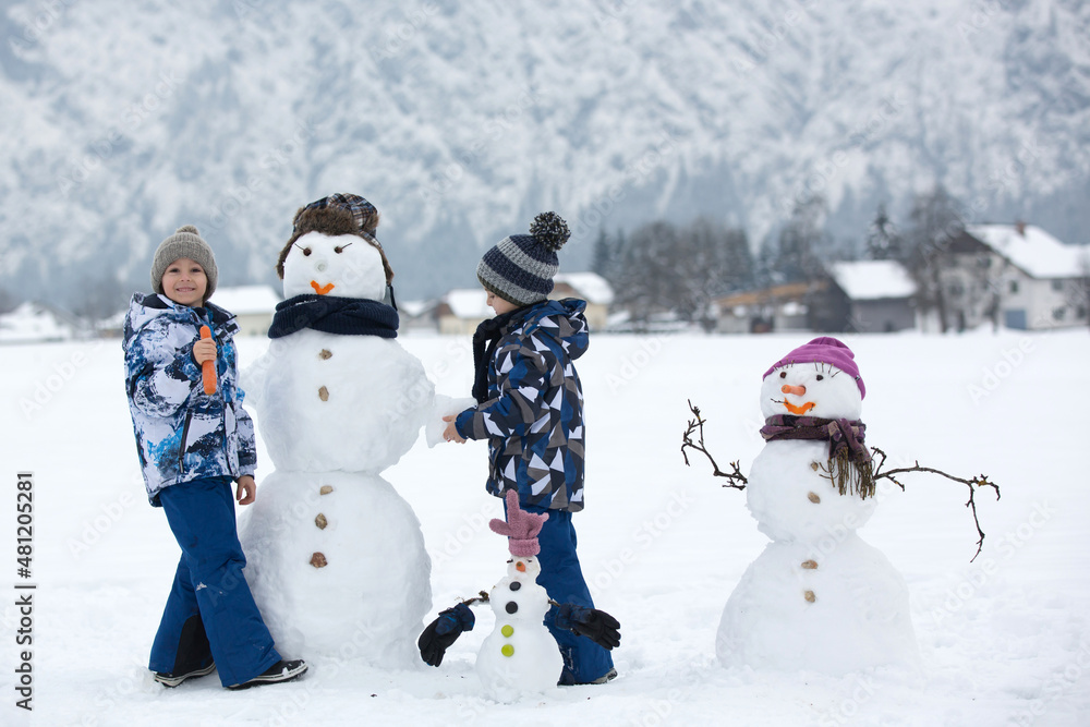 Sticker Family with children, building snowman in the park in little village in Austria