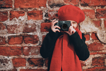 a girl at a brick wall takes pictures