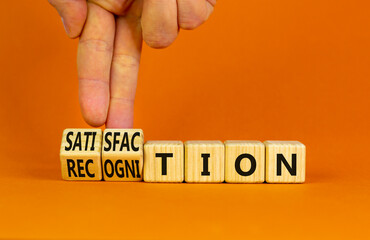 Satisfaction and recognition symbol. Businessman turns cubes changes the word recognition to satisfaction. Beautiful orange background, copy space. Businesss satisfaction and recognition concept.