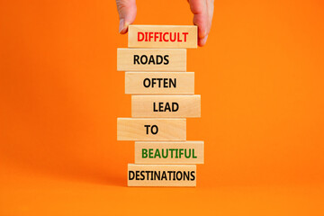 Motivational symbol. Blocks with words Difficult roads often lead to beautiful destinations. Beautiful orange background, copy space. Businessman hand. Business, psychology and motivational concept.