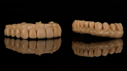dental prostheses for trying on the upper and lower jaws on black glass