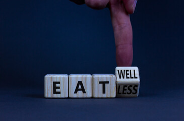 Eat well or eat less symbol. Businessman turns a wooden cube and changes words eat less to eat well. Beautiful grey table, grey background. Business, eat well or less concept. Copy space.
