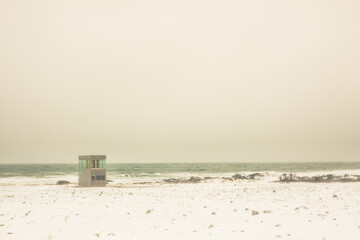 Shelter of glass and wood in the middle of a storm on the shore of the North Sea