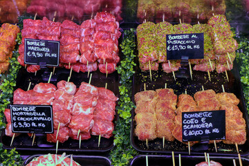 Various types of the famous bombette martinesi for sale in a butcher's shop. Meat rolls stuffed with cheese. In the signs written in Italian the various types of tastes - obrazy, fototapety, plakaty