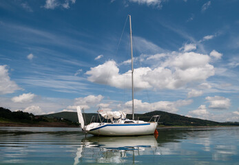 Small sailboat moored on the Lake Mucharz (Jezioro Mucharskie) reservoir, Lesser Poland Voivodeship (Małopolskie). © Longfin Media