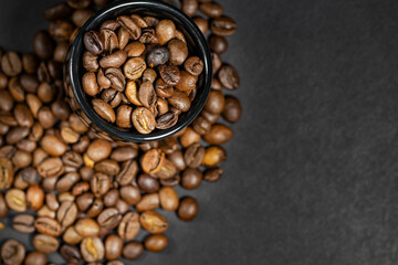 Roasted coffee beans on a black background, banner mockup, selective focus, top view, place for text.
