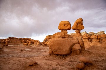 Fototapeta na wymiar Hoodoo formations, created by sandstone erosion, in a desert landscape in Goblin Valley State Park on a rainy spring day.