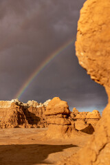 Hoodoo formations, created by sandstone erosion, in a desert landscape in Goblin Valley State Park on a rainy spring day.