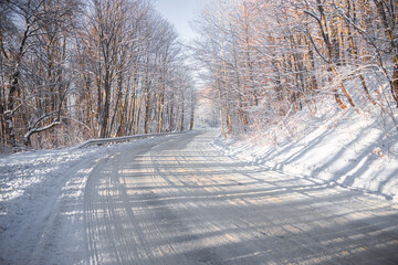 Obraz premium Beautiful empty winter road after the snowfall. Long road ahead. Travel in winter concept. No cars on the road. High quality photo