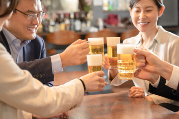 ビールで乾杯する会社帰りの打ち上げ飲み会手元