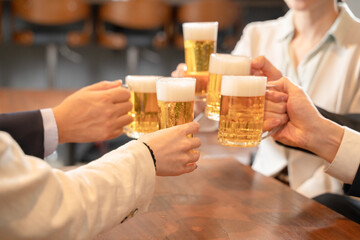 ビールで乾杯する会社帰りの打ち上げ飲み会手元