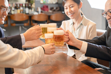 ビールで乾杯する会社帰りの打ち上げ飲み会手元