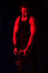 Fototapeta na wymiar muscular man. athlete on a black background with colored light. blur. portrait