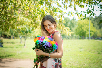 A young girl with flowers on the background of a green forest