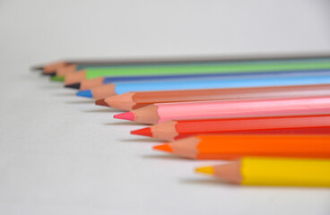 several colored pencils on a white background