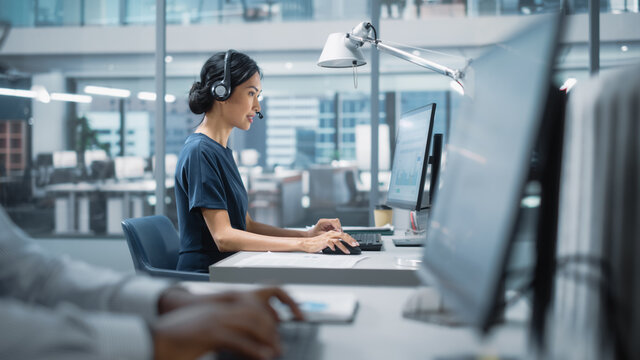 Professional Investment Traders Talking into Headset, Working on Computer with Screen Showing Finance Statistics, Charts Strategy, Stock Market, Telemarketing. Big Office Call Center. - Powered by Adobe