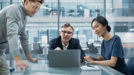 Multiethnic Diverse Office Conference Room Meeting: Team of Three Creative Entrepreneurs Talk, Discuss Growth Strategy. Stylish Young Businesspeople work on Digital e-Commerce Startup Project.