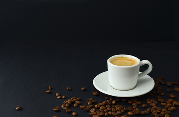 Black coffee and roasted coffee beans on table on a black background, small cup espresso couple, copy space