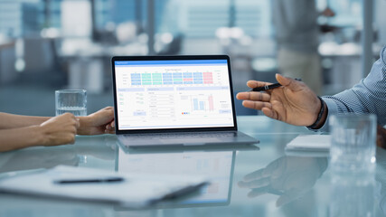 Close Up Shot of a Computer Screen. Office Meeting Room: Team of Two Creative Entrepreneurs Discuss Financial Data, Growth Strategy. Stylish Businesspeople work on Investment in Real Estate.