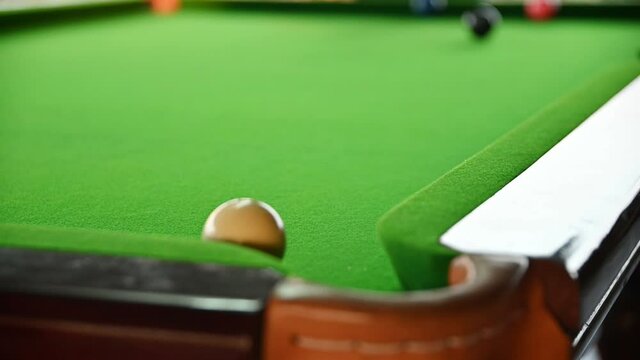 Man playing snooker with aiming for ball on bar