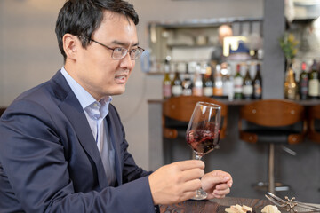 飲食店にてワインをテイスティングする男性