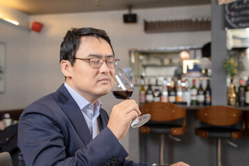 飲食店にてワインをテイスティングする男性