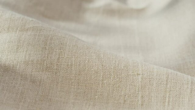 Beige fabric close-up, light brown cloth texture background. Macro shooting of cotton textile. 