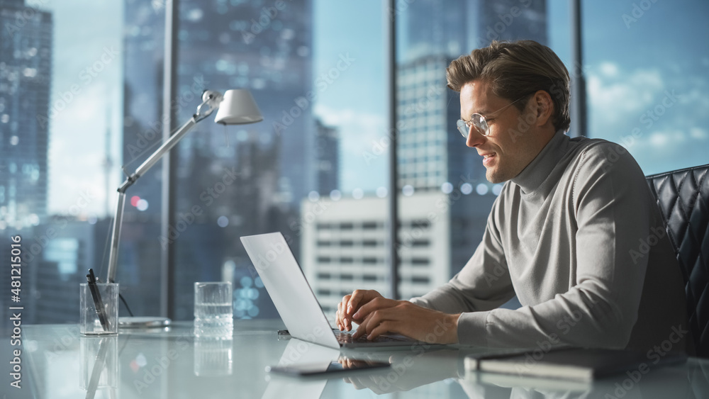 Poster creative businessman in a turtleneck jumper sitting in modern office, using laptop computer next to 