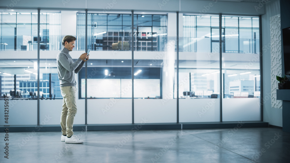 Poster handsome stylish interior designer standing in empty modern office and map it with an augmented real