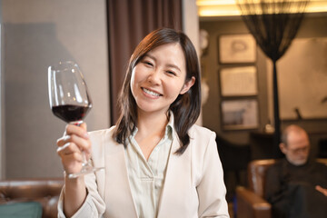 飲食店で赤ワインで乾杯をする女性